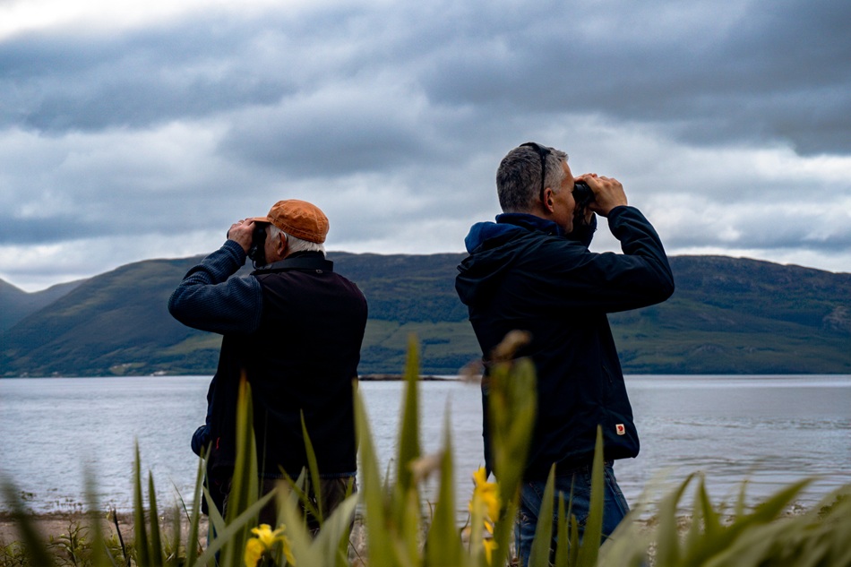 two men looking through binoculars